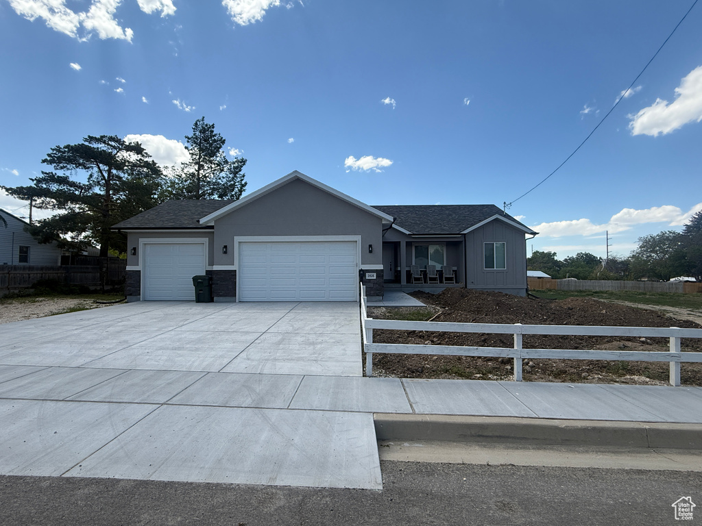 Ranch-style house featuring an attached garage, driveway, and a shingled roof