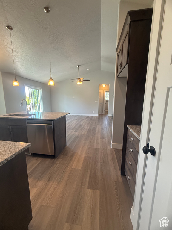 Kitchen with stainless steel dishwasher, a sink, wood finished floors, a ceiling fan, and dark brown cabinetry