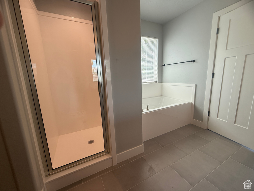 Full bathroom with a garden tub, a shower stall, tile patterned floors, and baseboards