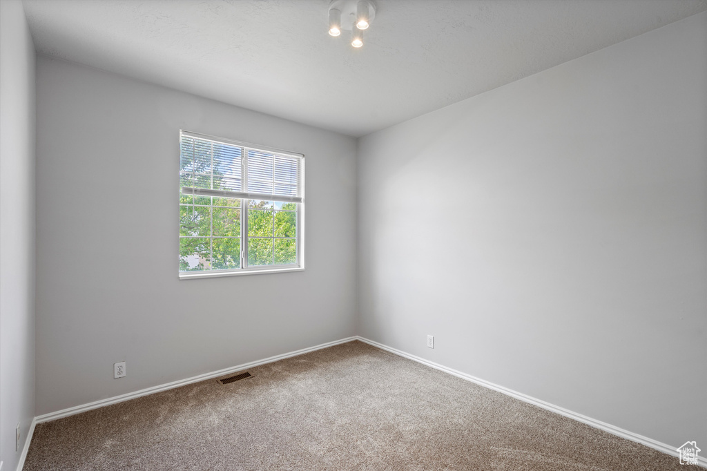 Carpeted empty room with baseboards