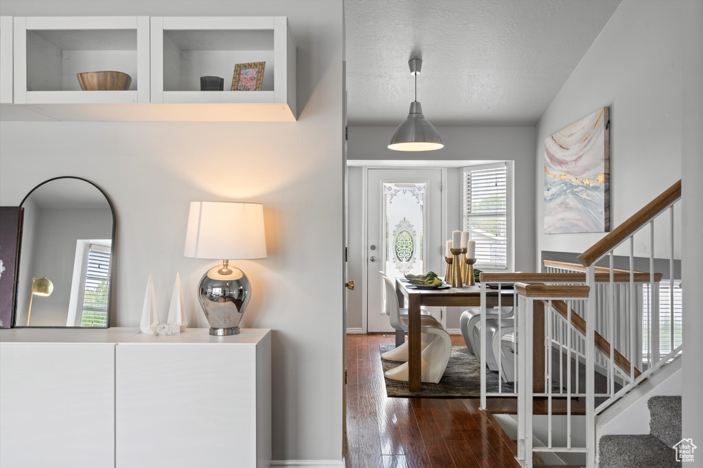 Foyer with hardwood / wood-style floors, stairway, vaulted ceiling, and a textured ceiling