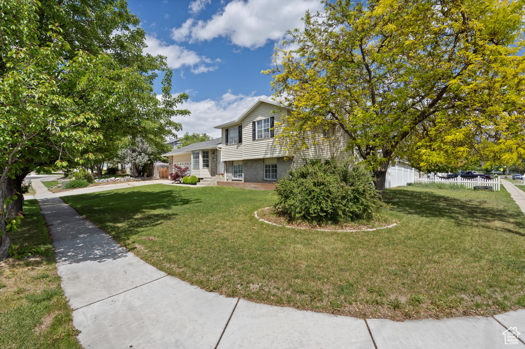 Tri-level home with brick siding and concrete driveway