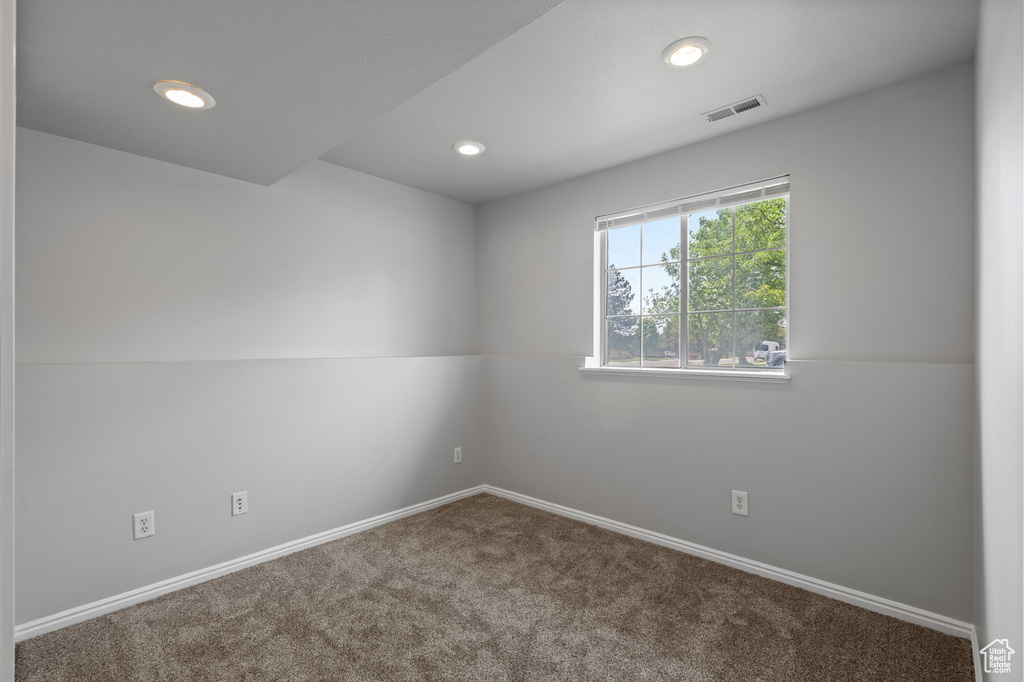 Carpeted spare room featuring baseboards and recessed lighting