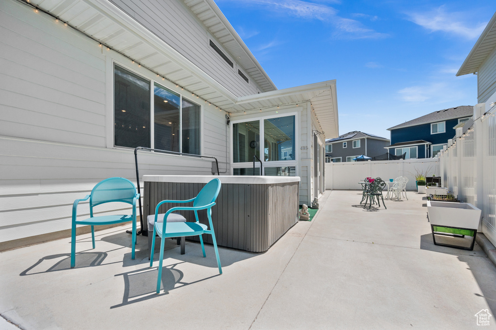 Fenced backyard with a patio and a hot tub