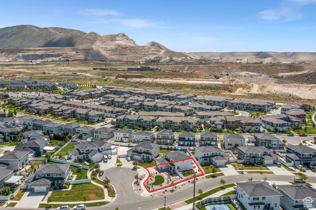 Aerial view of residential area with property parcel outlined and a mountainous background