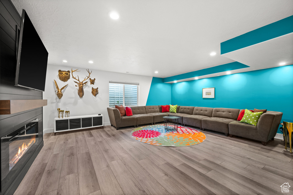 Living area with wood finished floors, a fireplace, recessed lighting, and baseboards
