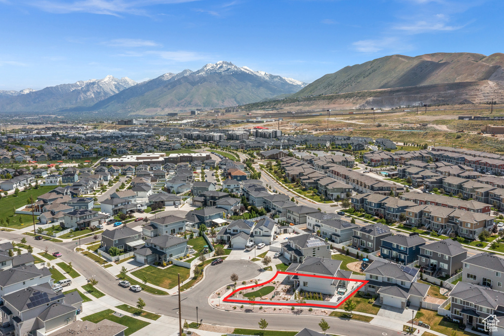 Aerial view of property and surrounding area featuring mountains, property boundaries highlighted, and nearby suburban area