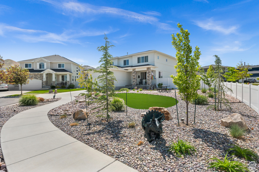 View of front of house featuring stone siding, curved driveway, and a residential view