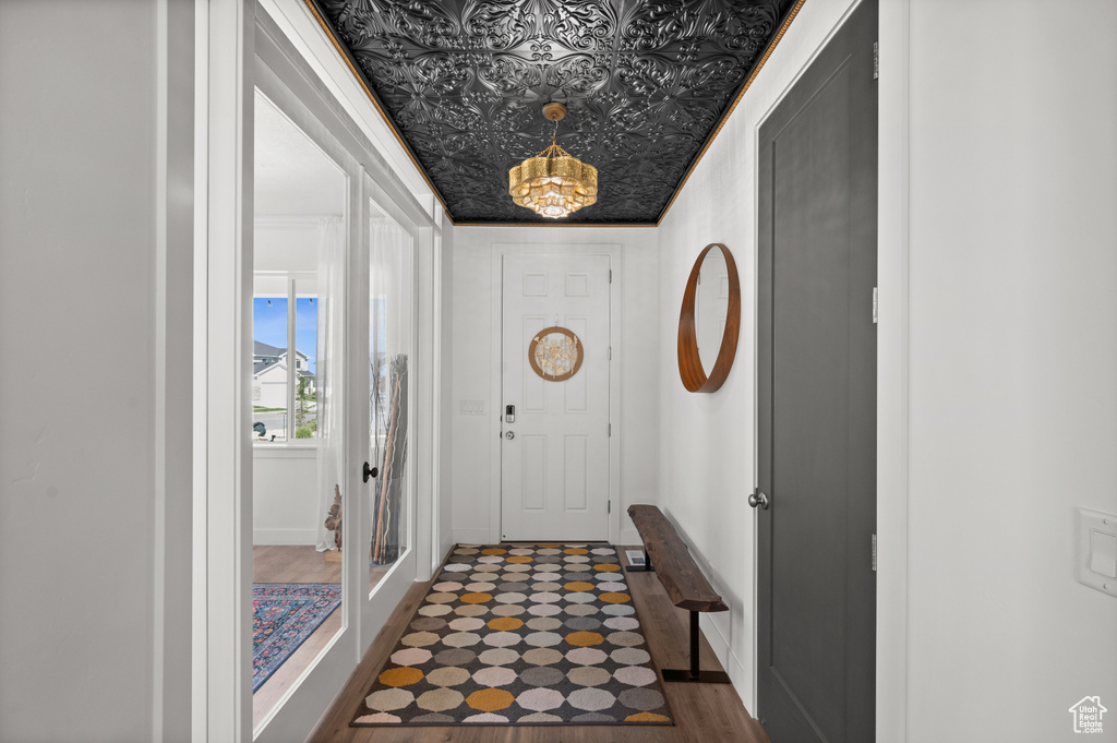 Entryway featuring a chandelier, baseboards, an ornate ceiling, and dark wood finished floors