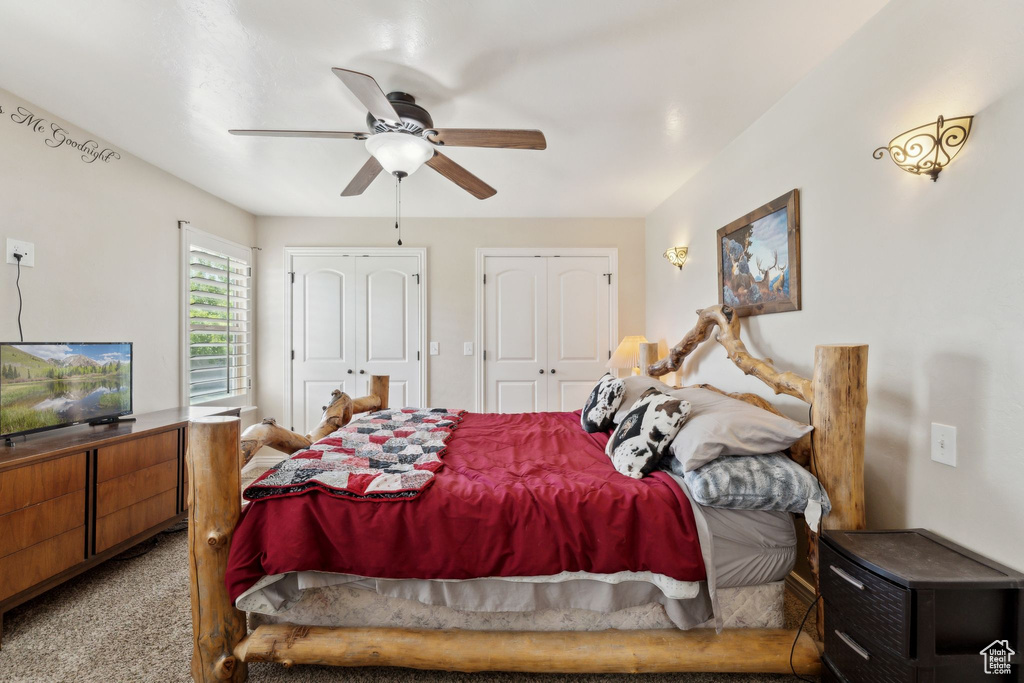 Carpeted bedroom with two closets and ceiling fan