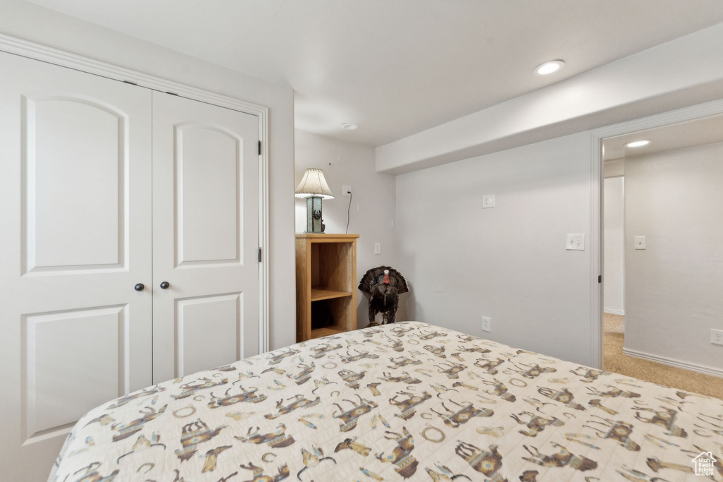 Carpeted bedroom with a closet, recessed lighting, and baseboards