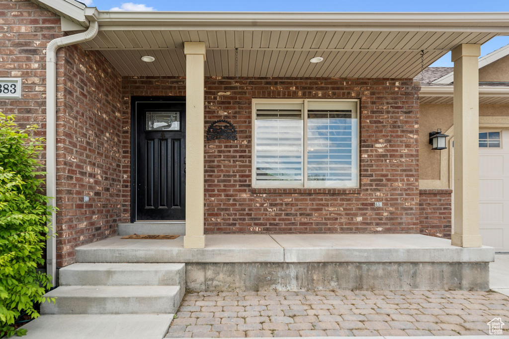 Property entrance with brick siding and covered porch