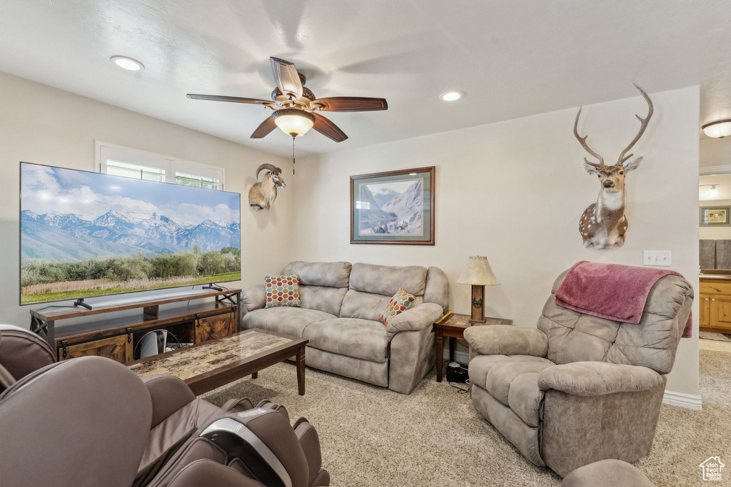 Living area featuring light colored carpet, ceiling fan, and recessed lighting