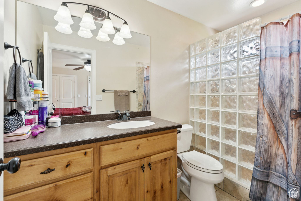 Bathroom featuring a shower with curtain, vanity, toilet, a ceiling fan, and tile patterned flooring