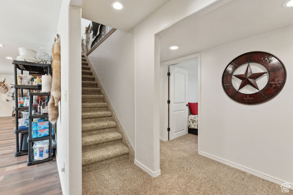 Stairs with recessed lighting, baseboards, and carpet floors