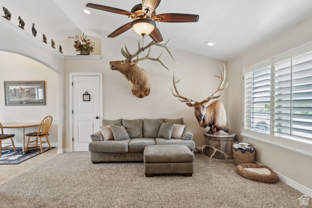 Carpeted living area with vaulted ceiling, healthy amount of natural light, a ceiling fan, recessed lighting, and baseboards