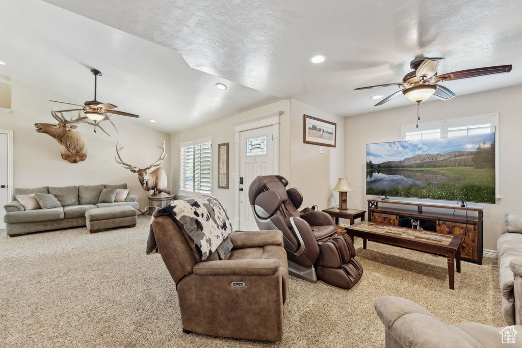 Carpeted living room featuring a ceiling fan, plenty of natural light, recessed lighting, and baseboards