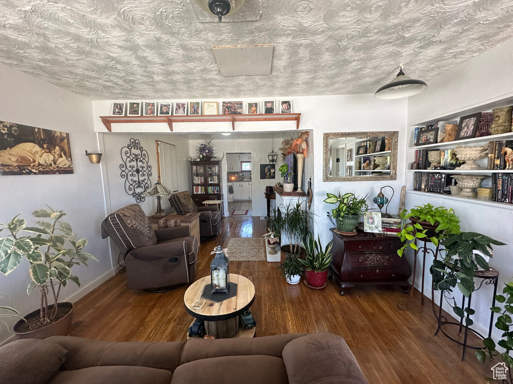Living room featuring wood finished floors, a textured ceiling, and baseboards