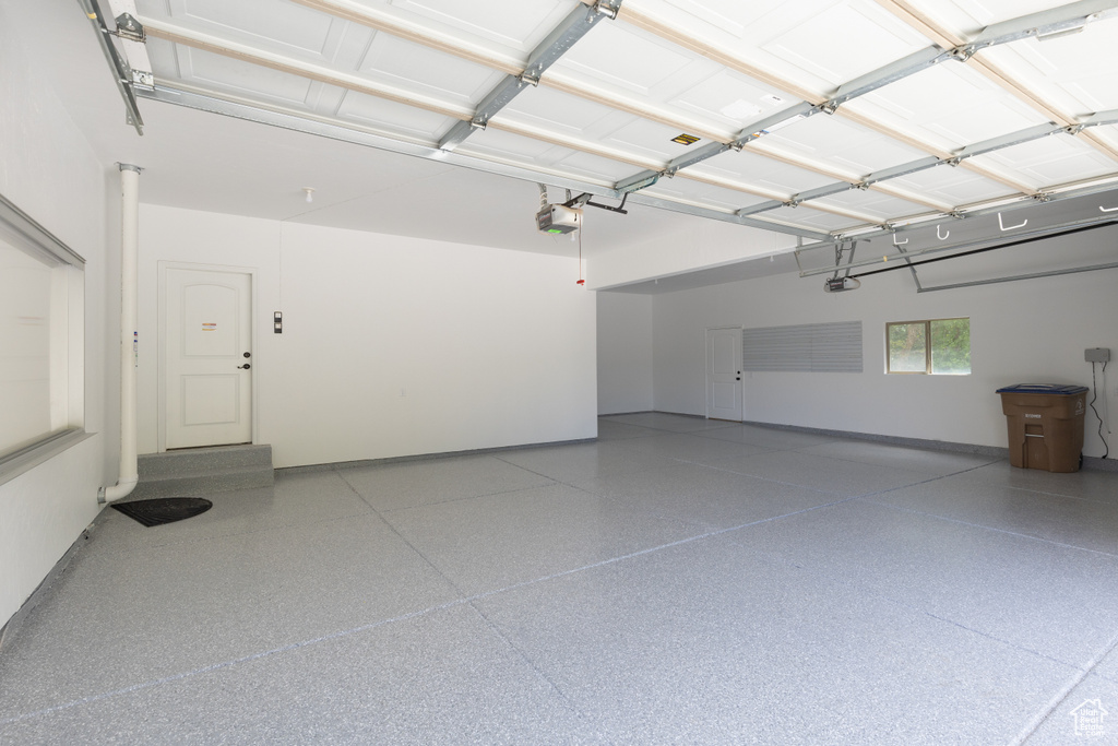 Garage featuring a garage door opener and baseboards