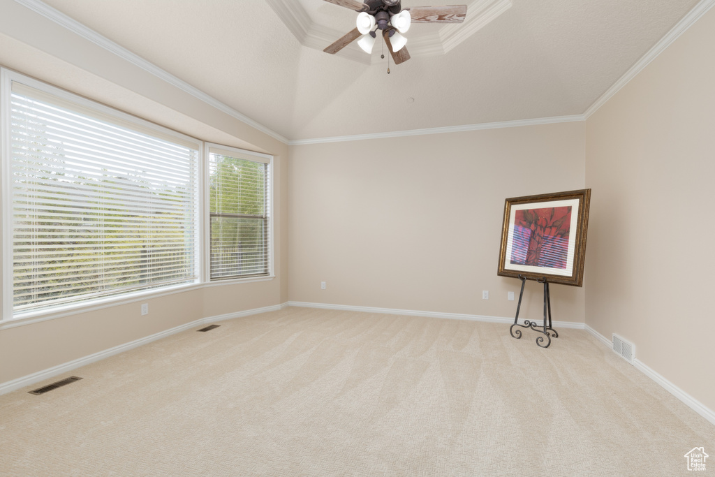 Unfurnished room featuring light carpet, a ceiling fan, ornamental molding, and baseboards