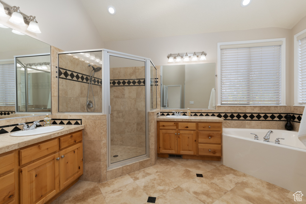 Full bath with a stall shower, a bath, two vanities, lofted ceiling, and recessed lighting
