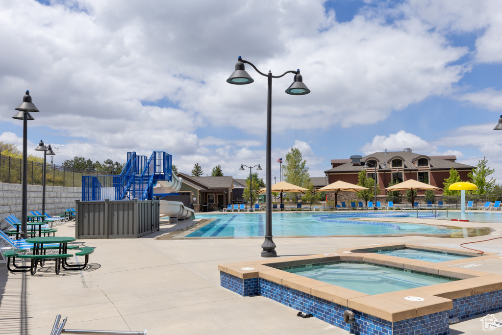Community pool with a community hot tub and a patio