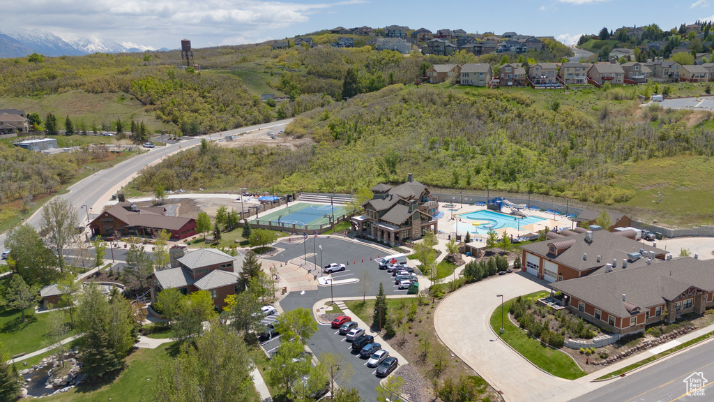 Aerial view of property and surrounding area with a pool and nearby suburban area