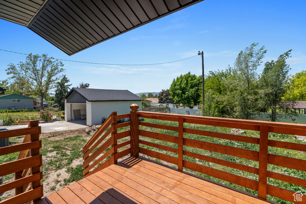 Deck featuring an outdoor structure and driveway