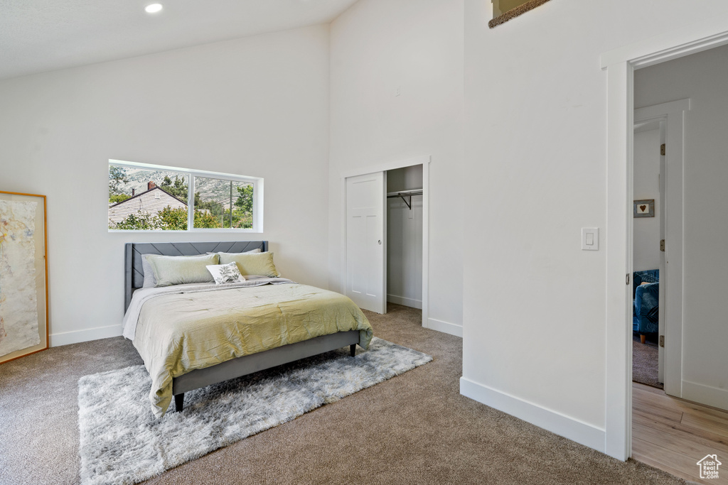 Bedroom with high vaulted ceiling, carpet flooring, baseboards, a closet, and recessed lighting