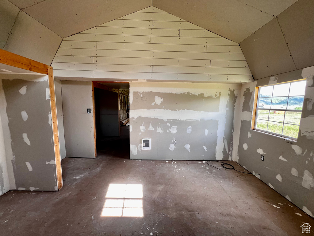 Empty room with lofted ceiling