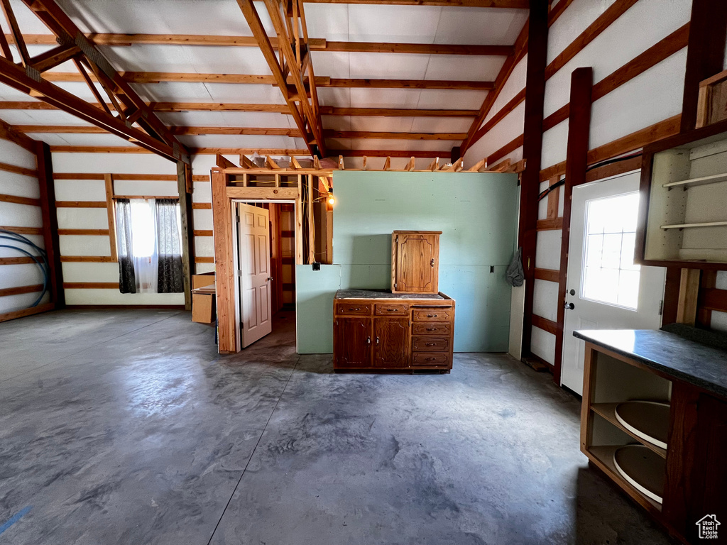 Miscellaneous room featuring concrete flooring and lofted ceiling
