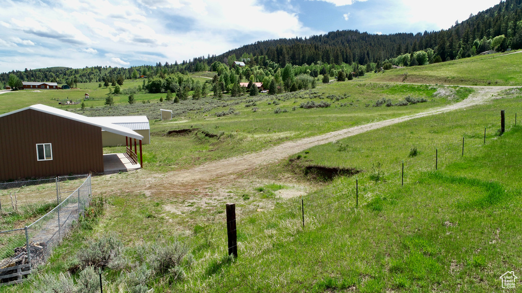 View of mountain backdrop featuring rural landscape and a forest