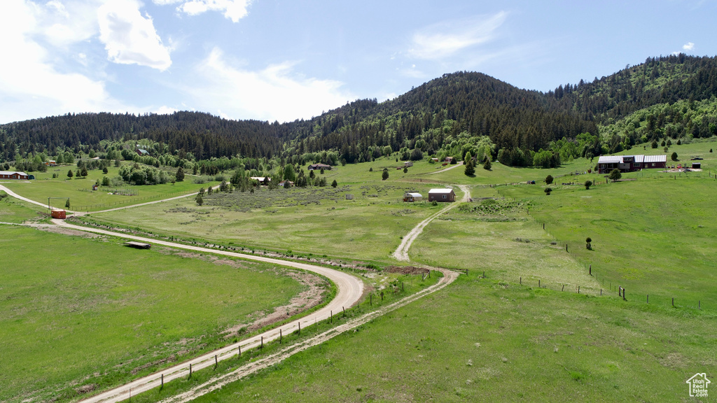 Aerial view of sparsely populated area featuring a forest, a mountain backdrop, and agricultural land
