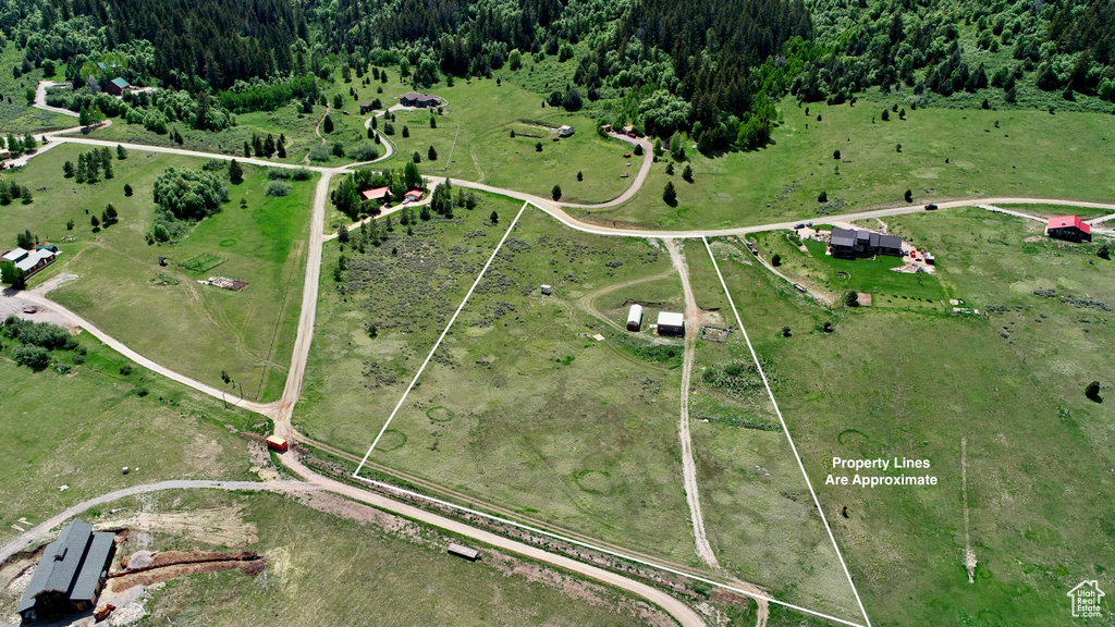 Aerial view of property and surrounding area featuring a forest, rural landscape, and property boundaries highlighted