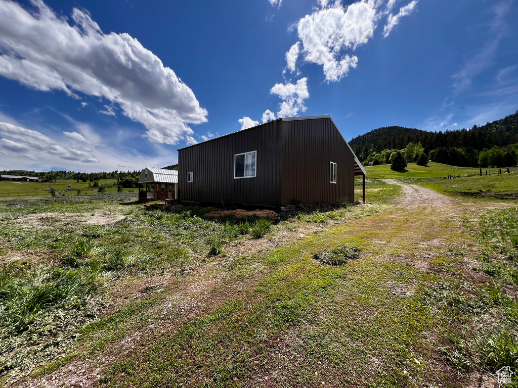 View of side of home with a forest view and a rural view