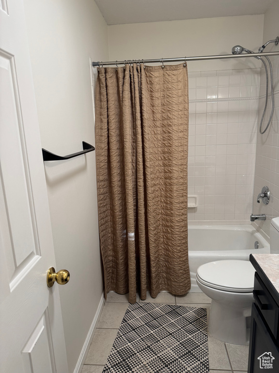 Bathroom with tile patterned flooring, toilet, shower / bath combo, and vanity
