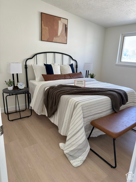 Bedroom featuring light wood-style flooring and a textured ceiling