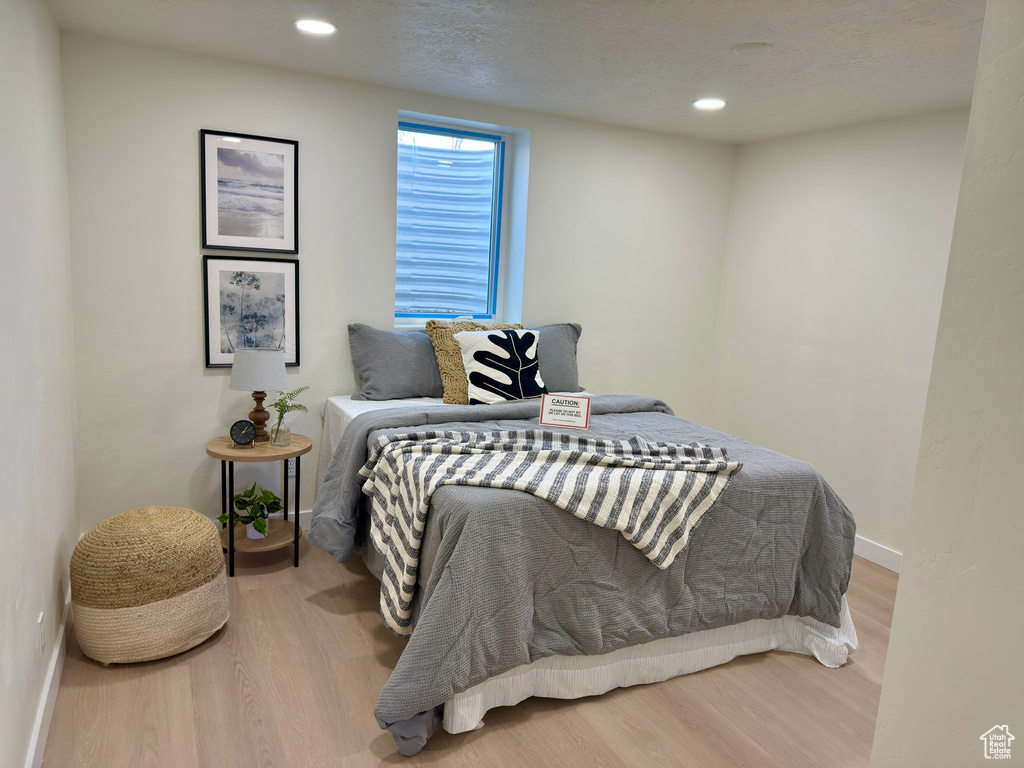 Bedroom featuring wood finished floors, recessed lighting, and baseboards