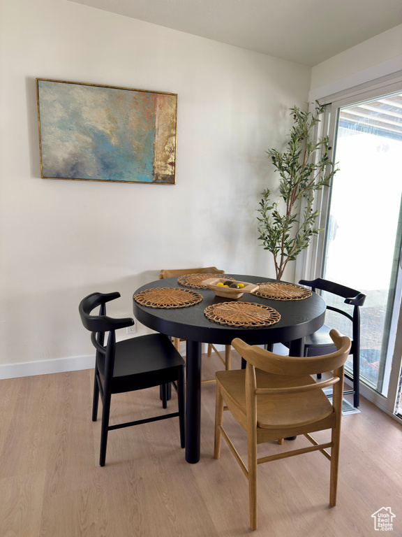 Dining area featuring light wood finished floors, breakfast area, healthy amount of natural light, and baseboards