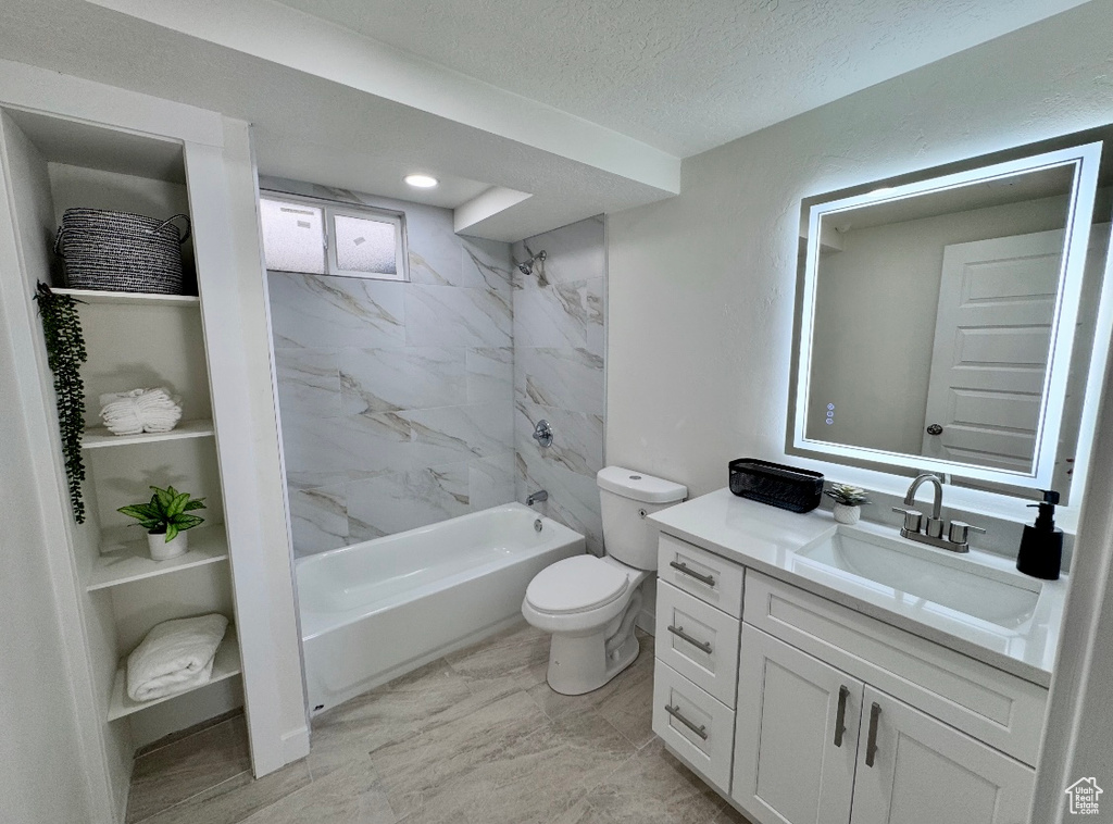 Full bathroom featuring toilet, vanity,  shower combination, and a textured ceiling