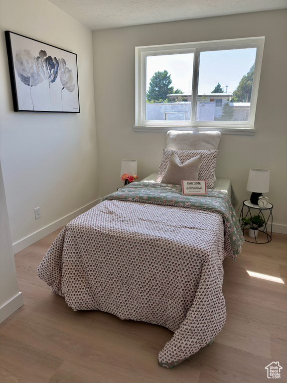 Bedroom featuring baseboards and wood finished floors