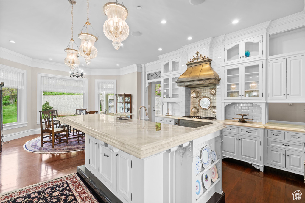 Kitchen with a chandelier, dark wood-type flooring, white cabinetry, backsplash, and recessed lighting