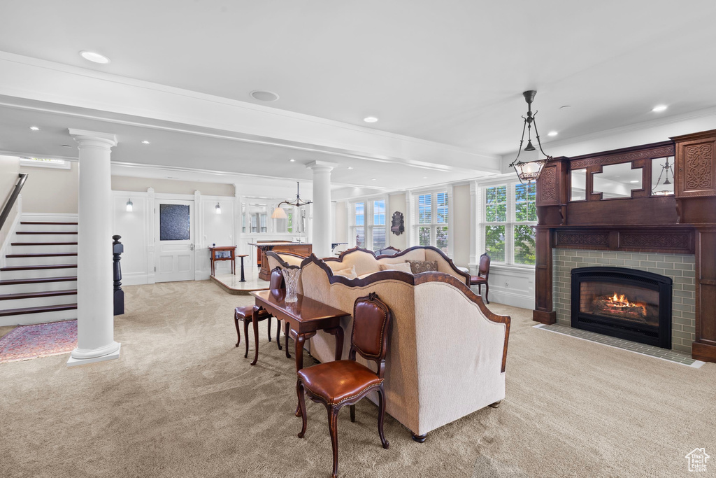 Living room with light carpet, ornamental molding, recessed lighting, stairs, and a fireplace