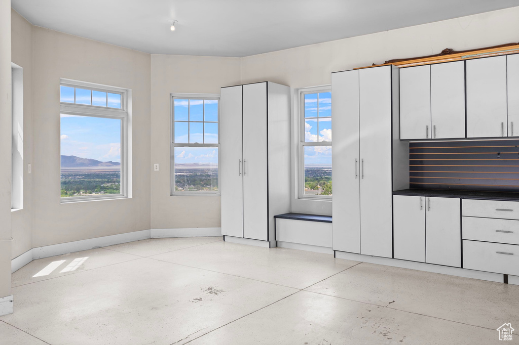 Unfurnished dining area featuring baseboards and concrete floors