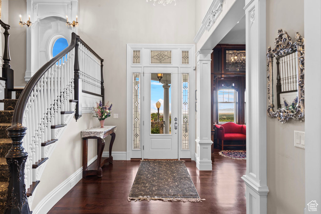 Foyer entrance with wood finished floors, a high ceiling, stairway, and baseboards
