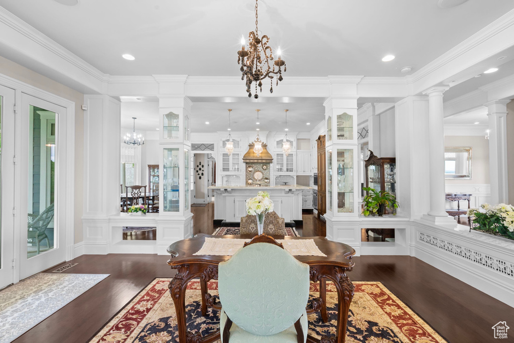 Dining space featuring a chandelier, ornate columns, dark wood-type flooring, ornamental molding, and recessed lighting