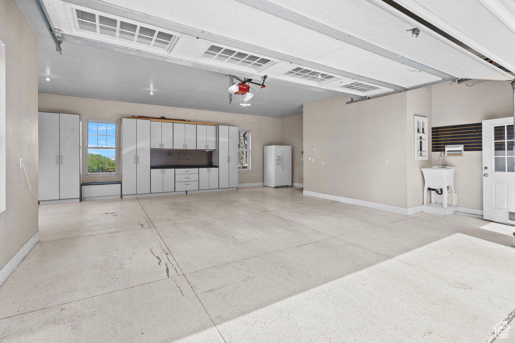 Garage featuring baseboards and a garage door opener