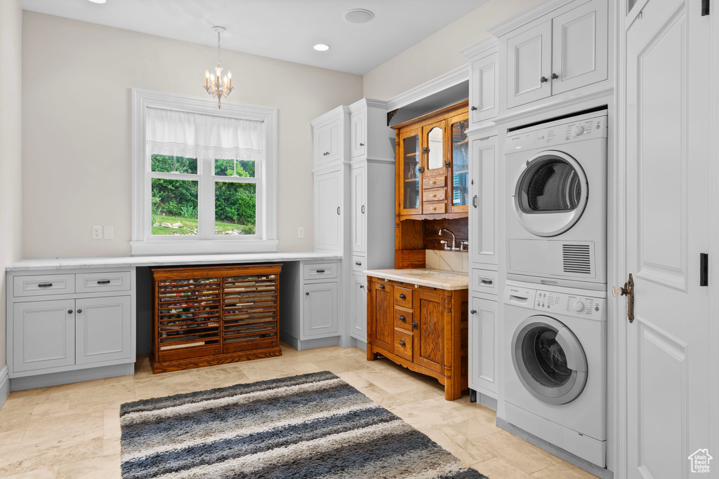 Laundry room with stacked washer / drying machine, a chandelier, and recessed lighting