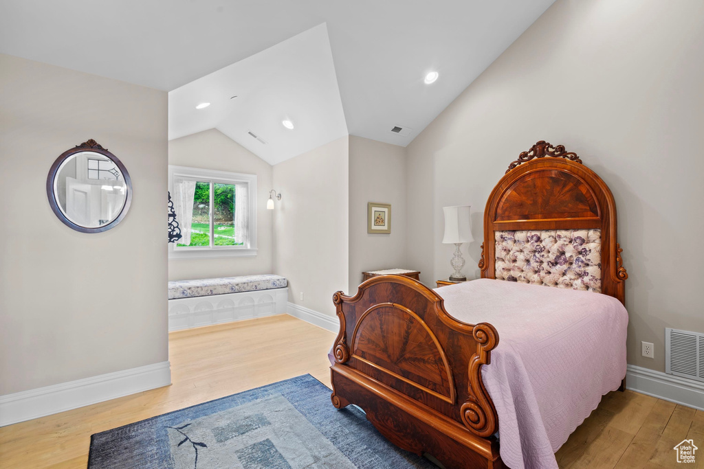 Bedroom featuring wood finished floors, vaulted ceiling, recessed lighting, and baseboards