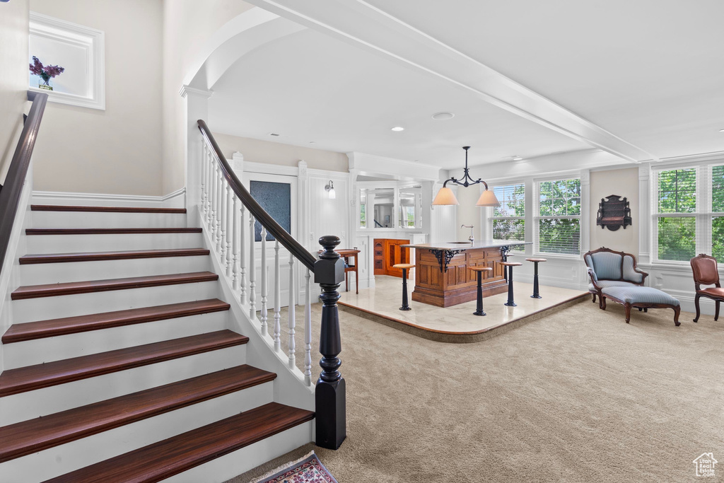 Stairs featuring carpet, wainscoting, and arched walkways